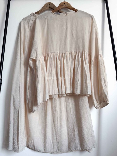 Ensemble deux pièces femme musulmane beige présenté sur cintre.